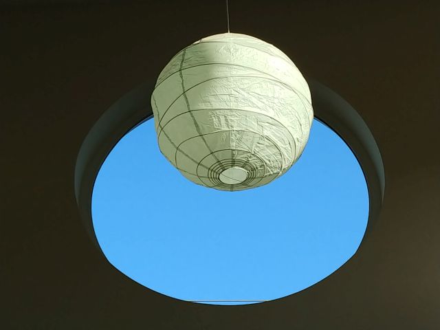 A lamp hanging in front of a circular window
